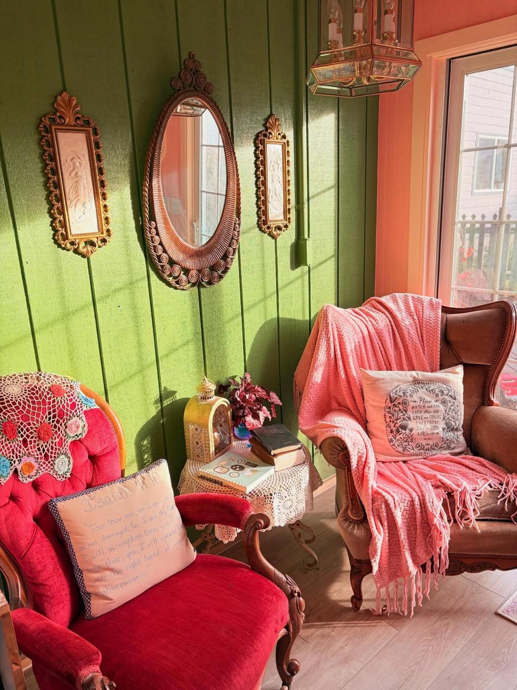 A corner of the studio with antique mirrors and red velvet chairs